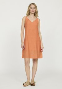 Robe orange sans manches avec un décolleté en V, fabriquée en tissu léger. Forme simple en A, longueur genou avec une texture subtile.