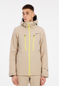 Beige wasserfeste Jacke mit Kapuze, ausgestattet mit zwei vorderen Reißverschlusstaschen mit fluoreszierend gelben Akzenten und Belüftungsperforationen.