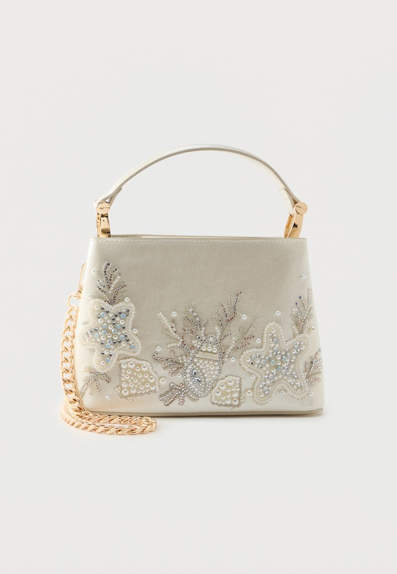 Malá krémová kabelka se zlatým řetízkem, ozdobami ve tvaru mušlí a hvězdic, a jedinou horní rukojetí.