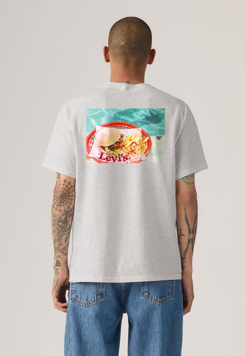 Γκρι βαμβακερό t-shirt με πολύχρωμο σχέδιο που απεικονίζει ένα μπέργκερ και πατάτες σε ένα κόκκινο καλάθι. Το σχέδιο περιλαμβάνει τη λέξη "Levi's" σε εμφανές σημείο.