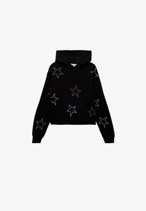 Sudadera corta negra con diseños de estrellas blancas. Hecha de tela suave, con capucha ajustable y puños acanalados.