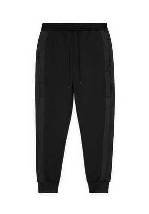 Pantalones jogger negros con cintura elástica, cordón, bolsillos laterales y puños acanalados sobre un fondo blanco.
