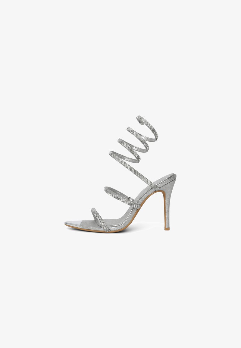 Glittery silver high-heeled sandal with spiral straps, open toe, and single metallic accent. Smooth surface and slender heels.