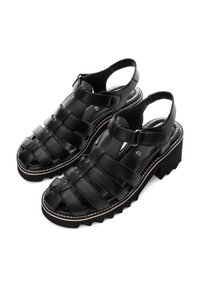Black leather sandals featuring a woven design, open toe, adjustable strap, and a chunky sole with a white accent line.
