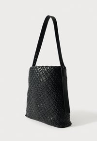 Μαύρη υφαντή δερμάτινη τσάντα με απαλό υφή, ορθογώνιο σχήμα και μακριά ρυθμιζόμενη λουρίδα. Διαθέτει διακριτικό γυαλιστερό φινίρισμα.