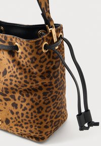 Borsa a secchiello in suede con stampa leopardata e dettagli in pelle nera; presenta una chiusura con coulisse e hardware color oro. Superficie testurizzata, forma arrotondata.