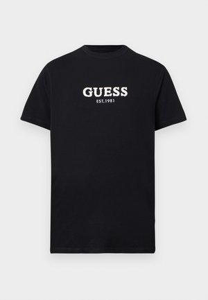 Schwarzes Kurzarm-T-Shirt mit weißem "GUESS EST. 1981"-Schriftzug mittig auf der Brust, Rundhalsausschnitt, einfarbiger Hintergrund.