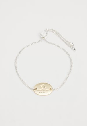 Sølvkæde armbånd med justerbar lås og gyldent ovalt vedhæng indgraveret med "RL Ralph Lauren Est. 1967" på hvid baggrund.