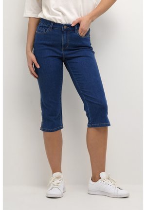 Knee-length denim capris in dark blue with a fitted silhouette, regular waistband, and a classic five-pocket design. Worn with white sneakers.