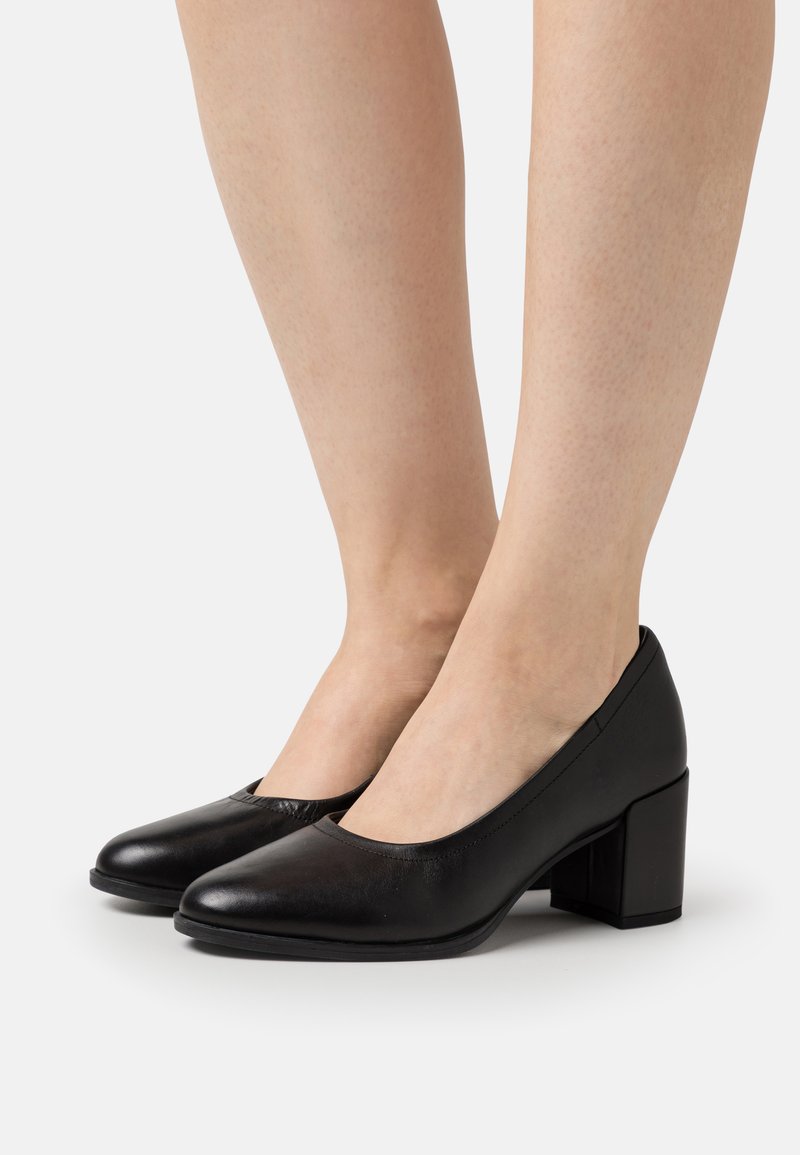 Scarpe nere in pelle con tacco blocco e punta arrotondata, dalla finitura liscia. Design a vamp basso che rivela la parte superiore del piede.