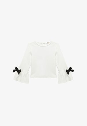Blusa blanca de manga larga con mangas acampanadas que presentan lazos de cinta negra en los puños, tejido texturizado y un escote redondo con un pequeño orificio en la parte trasera.