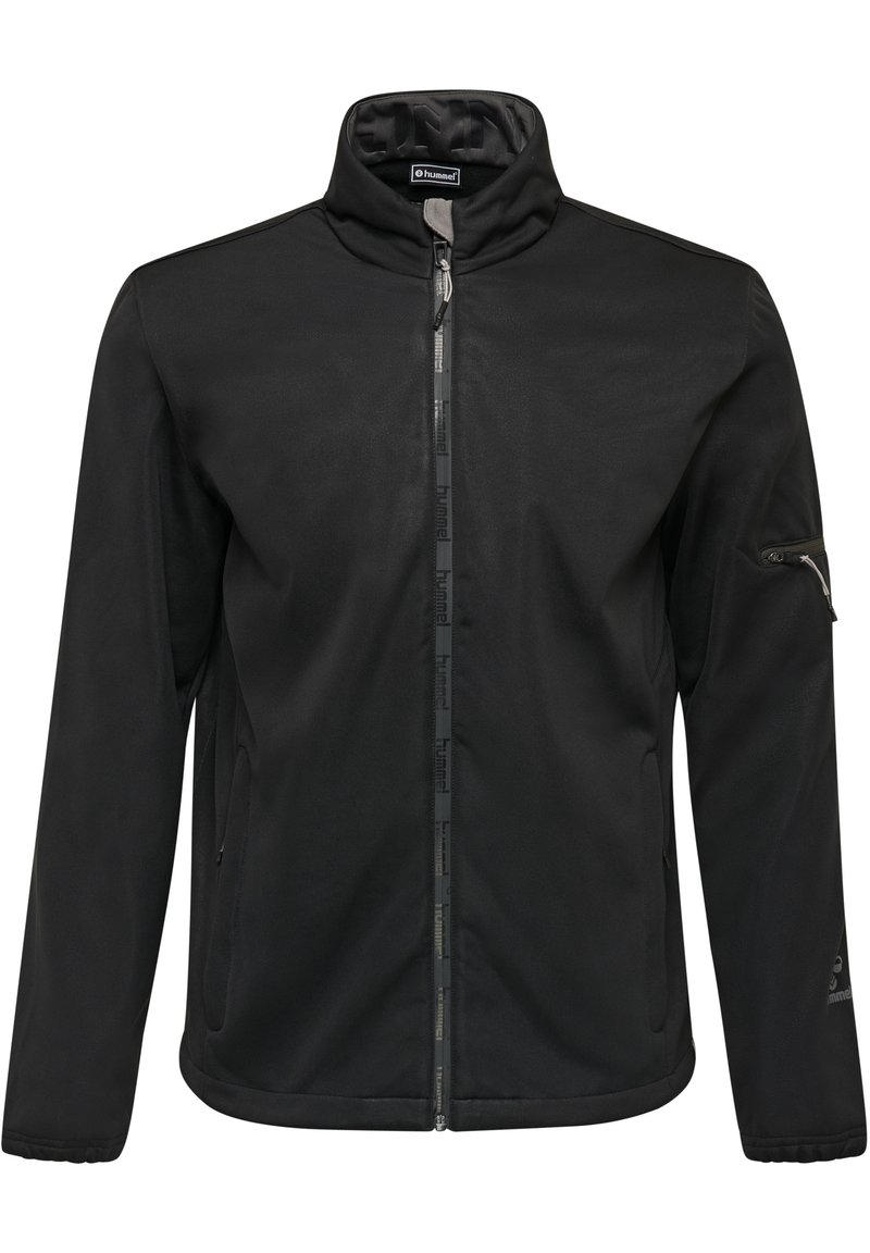Sort softshell jakke med høj krave, frontlynlås, lynlåslomme på venstre arm og diskret logo detajle på ærmet. Glat tekstur.