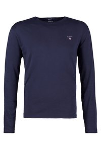T-shirt a maniche lunghe di colore blu navy in cotone, con scollo a girocollo e un piccolo logo sul lato sinistro del petto. Texture liscia su tutta la superficie.