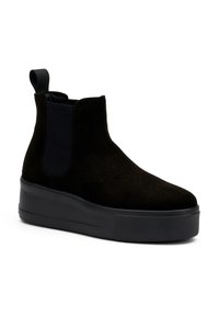 Las botas de tobillo de ante negro presentan un upper texturizado, paneles laterales elásticos y una suela de plataforma de goma gruesa. Incluyen una lengüeta para facilitar el uso.