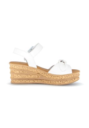 White wedge sandal with tan textured platform sole, adjustable ankle strap, and decorative knot on front strap.