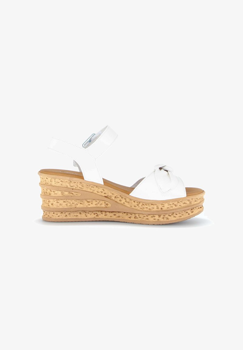White wedge sandal with tan textured platform sole, adjustable ankle strap, and decorative knot on front strap.