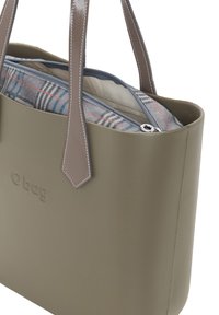 Olijfgroene, gestructureerde rubberen handtas met twee grijze handvaten, een ritsvak met een geruite voering en een reliëflogo aan de voorkant.