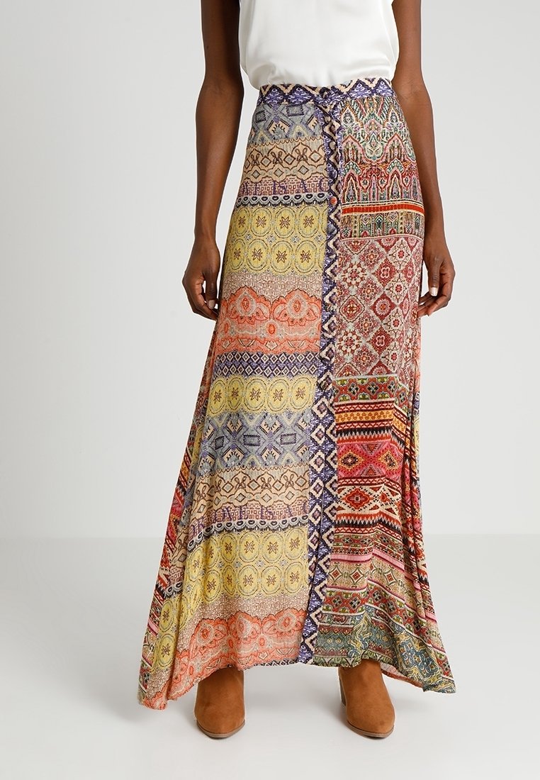 Maxi-rok met een patchworkontwerp in levendige kleuren, met geometrische en bloemmotieven, gemaakt van lichtgewicht stof.