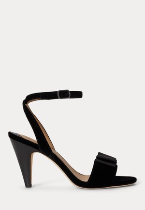 Sandale noire à talons hauts avec bride de cheville, bout ouvert et un nœud décoratif sur la bande avant.