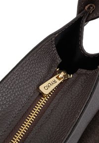 Hnedá kožená taška z vnútra so zlatým zipsom a ťahacím jazdcom. Textúrovaný povrch, hladká podšívka a viditeľné kontrastné hnedé prešívanie.