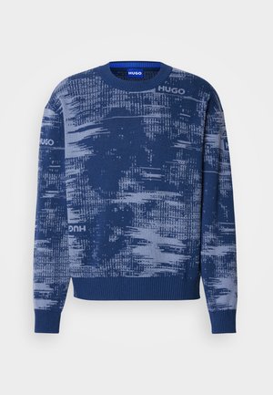 Pulover albastru cu guler rotund, cu un model abstract pixelat și textul repetat "HUGO" în nuanțe mai deschise de albastru.
