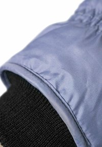 Vahvistettu hiha vaaleansinisestä kankaasta, jossa on sileä pinta, ja se ympäröi mustaa neulottua osaa. Varustettu kerättyä hihansuut ahtaan istuvuuden saavuttamiseksi.