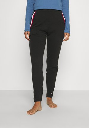 Pantalones de chándal negros hechos de material suave, con bolsillos laterales y franjas en rojo, blanco y azul. Diseño de pierna ajustada con puños elásticos.