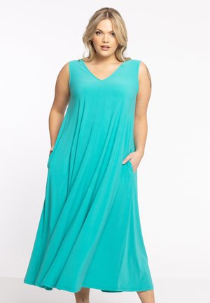 Ein türkisfarbenes, ärmelloses Maxikleid mit V-Ausschnitt, seitlichen Taschen und einer fließenden Silhouette aus leichtem, glattem Stoff.