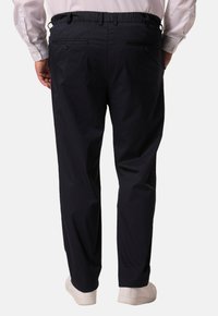 Námořnické kalhoty s elastickým pasem, zadními našitými kapsami a rovnými nohavicemi. Materiál vypadá lehký a má hladkou texturu.