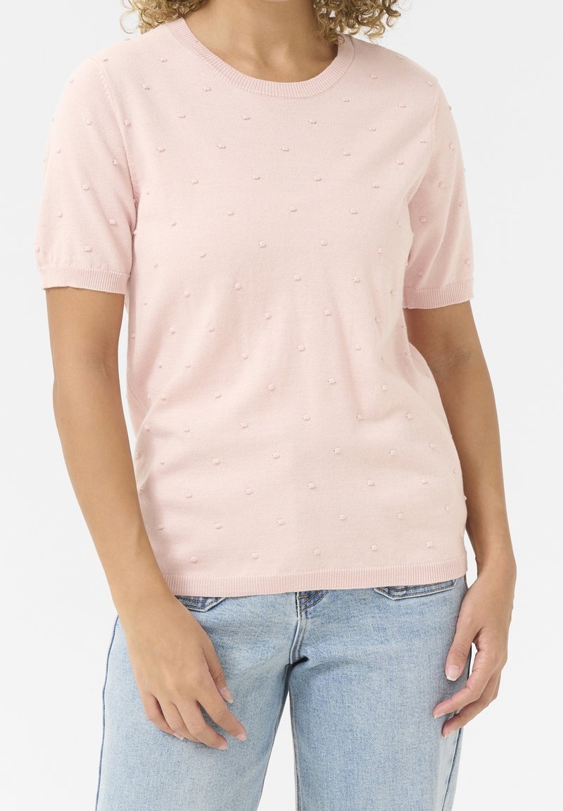 Hellrosa, kurzärmliger Pullover mit rundem Halsausschnitt und strukturiertem Oberflächenmuster aus kleinen, erhabenen Punkten. Weicher Stoff und gerippte Bündchen.