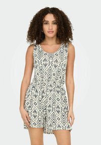 Mouwloze rompertje in crème met marineblauw abstract patroon, elastische taille en losvallende korte benen. Zachte stof met subtiele textuur.