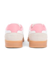 Λευκά αθλητικά παπούτσια με ροζ δερμάτινες λεπτομέρειες και μπεζ σουέντ τακούνι, με σόλα από καουτσούκ γκαμ και υφασμάτινη υφή. Καθαρός, σύγχρονος σχεδιασμός.