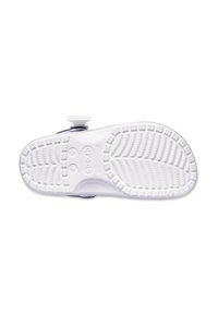 Vita Crocs med en texturerad sula som har djupa spår och kanter. Utformade med ett band för säker passform, idealiska för komfort och lätt användning.