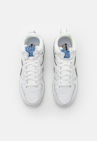 Sneaker alte bianche in pelle con accenti azzurri chiari, punta perforata, stringhe bianche piatte e etichetta del marchio sulla linguetta.