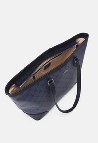 Sac fourre-tout marine en matériau texturé, avec des poignées doubles, une poche zippée à l'intérieur et un accent logo à l'extérieur.