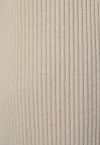 Beiger Cord-Stoff mit vertikaler Ripptextur, feinen Linien, weicher Haptik und leichtem Glanz; keine sichtbaren Muster oder Verzierungen.