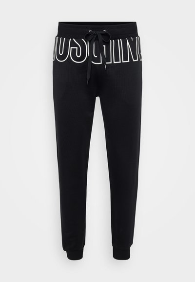 Black sweatpants made of soft fabric, featuring a drawstring waist and white logo print on the front, tapered legs with ribbed cuffs.