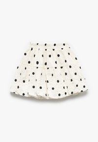 Falda blanca de volantes con lunares negros. Confeccionada en un tejido texturizado y con una cintura elástica para un ajuste cómodo.