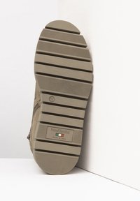 Semelle en suède beige avec un motif texturé comportant des rainures horizontales, un logo de marque en relief et une étiquette "made in Italy". Taille 37.