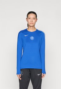 Long-sleeve blue athletic shirt made of smooth fabric, featuring a round neck, logo on the chest, and contrasting white shoulder accents.