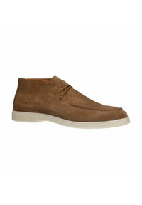 Bottines en suède marron avec une semelle en caoutchouc blanche, à bout rond et un simple détail de couture. Lacets avec un matériel minimal.