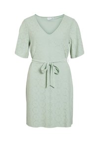 Ljusgrön klänning i strukturerad tyg med V-ringning, korta ärmar och ett knytbälte i midjan. Har perforerade cirkulära mönster.
