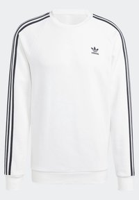 Biała bluza Adidas z długim rękawem, z czarnymi trzema paskami wzdłuż rękawów i małym czarnym logo Adidas po lewej stronie klatki piersiowej.