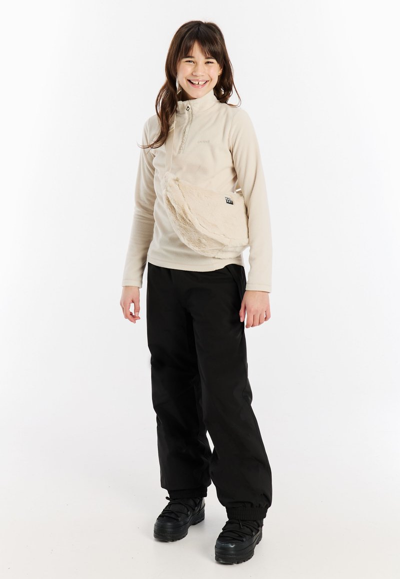 Beige Fleece-Oberteil mit halbem Reißverschluss-Kragen, kombiniert mit schwarzen weiten Hosen und einer strukturierten, cremefarbenen Umhängetasche. Schwarze Schuhe runden das Outfit ab.