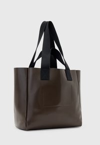 Borsa a tracolla marrone lucida con manici in tessuto neri, forma rettangolare e tasca anteriore. Texture liscia e design minimalista.