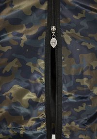 Camouflage-stof met een patroon in donkergroene, blauwe en zwarte tinten. Centrale rits met zilverkleurige hardware en een merk pull-tab.