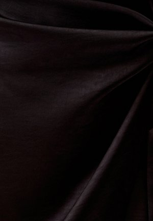 Czarna tkanina o gładkiej fakturze, z delikatnymi fałdami i lekkim połyskiem, tworząca bogaty i głęboki wygląd.