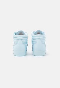 Ljust blå höga sneakers med slät läderstruktur, vadderad krage och vita accenter, med en platt gummisula och subtila sömdetaljer.