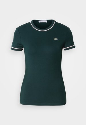 Dunkelgrünes T-Shirt mit kurzen Ärmeln, tailliertem Schnitt, mit weißen Akzenten am Kragen und an den Ärmeln, versehen mit einem kleinen Lacoste-Logo auf der Brust.