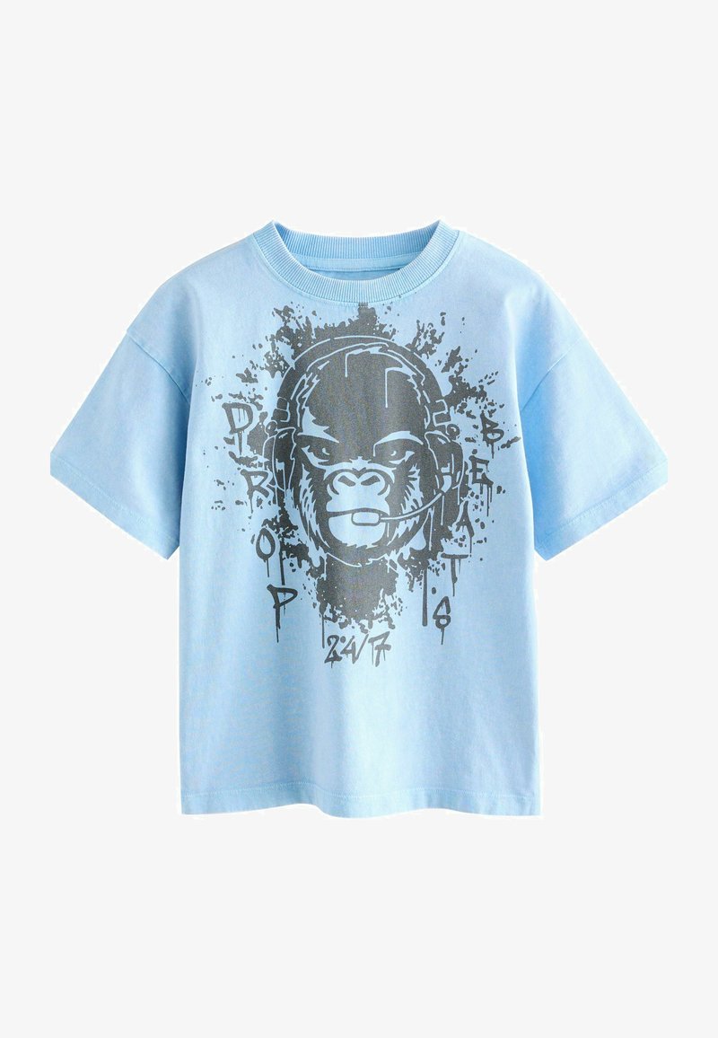 Lyseblå t-shirt med korte ærmer med grafik af en gorilla iført et headset og ordene "PRO DROP BEATS 24/7" i sort malingssprøjt-stil.